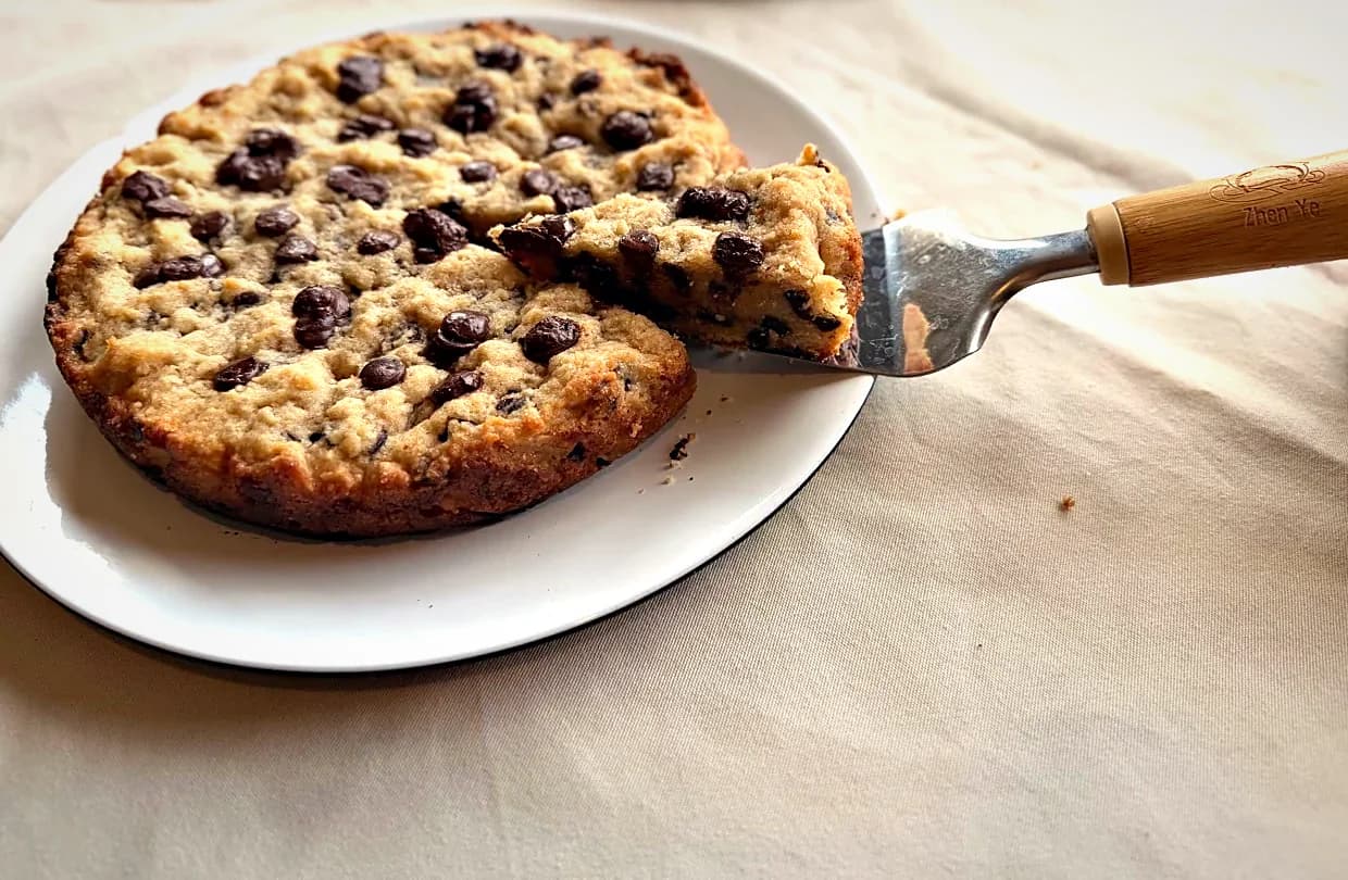 A slice lifted from a chocolate-chip cookie pie