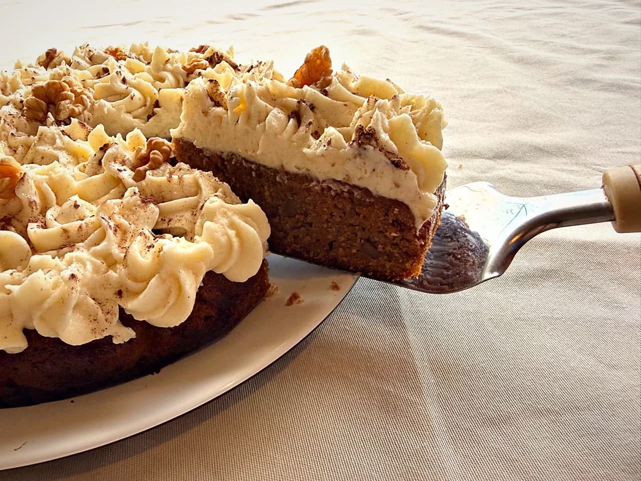 A slice lifted from a walnut cream cake